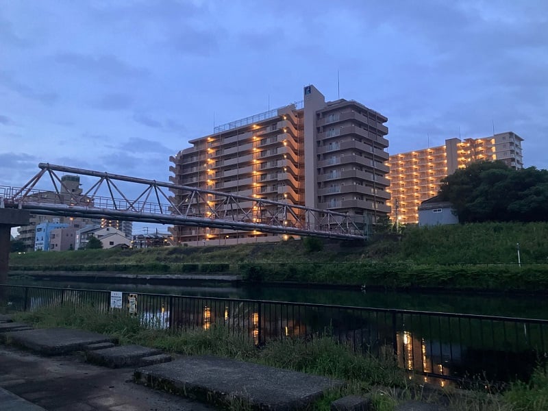 street view of buildings and bridge in Aikawa at sunrise