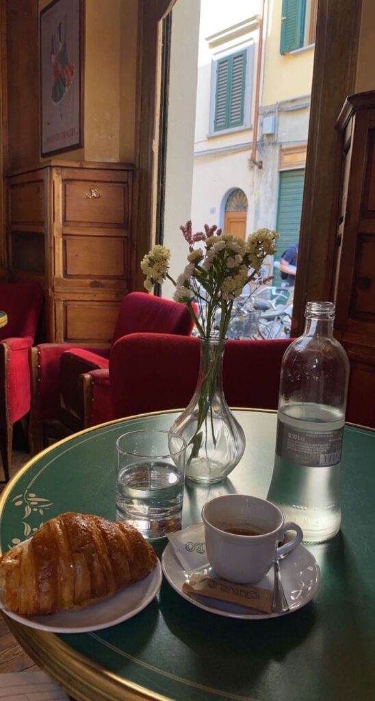 croissant. mug and flowers on table