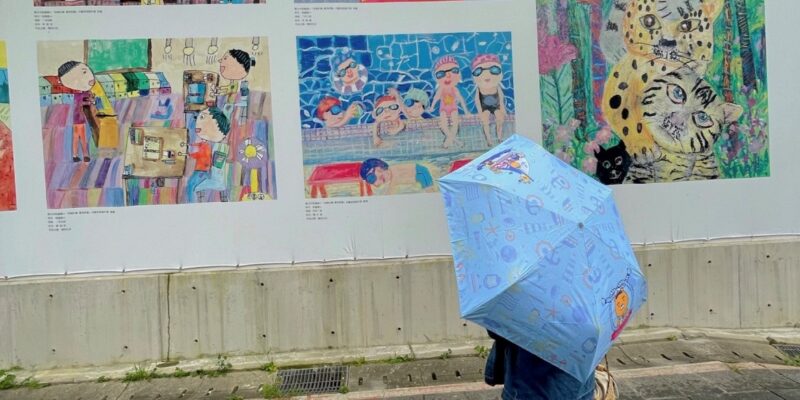 girl with umbrella in front of art