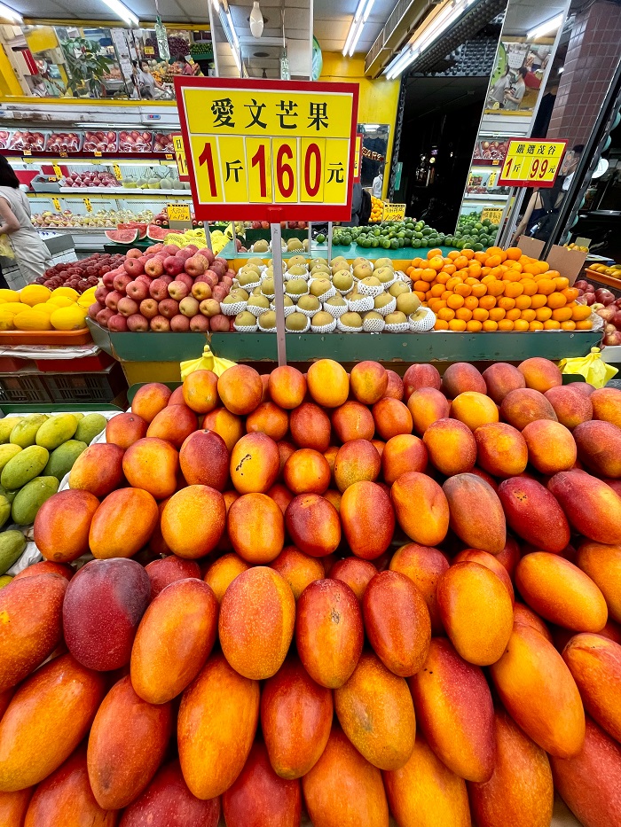 Market with various fruits including mangoes and apples