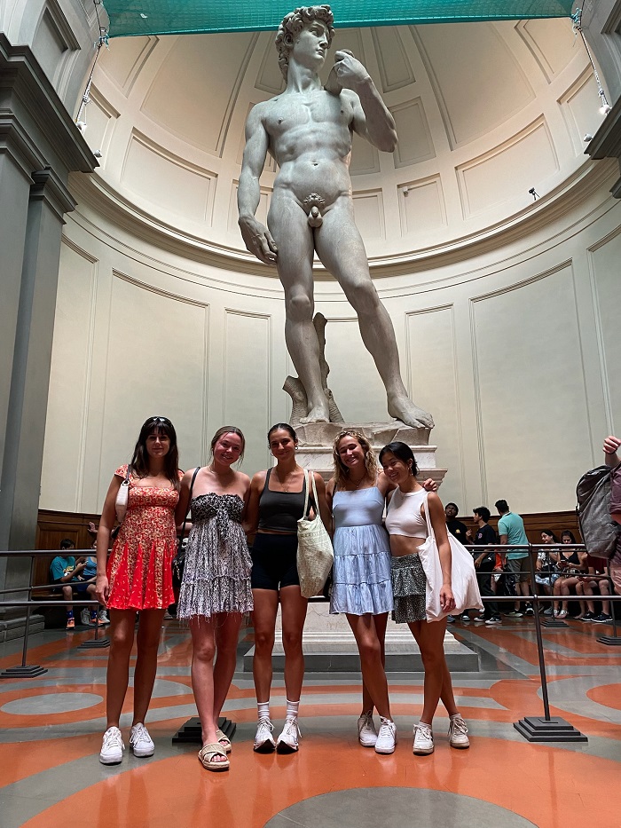 Five friends standing in front of david statue