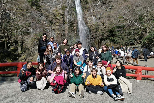 CET Japan students and local roommates in front of a waterfall on a hike
