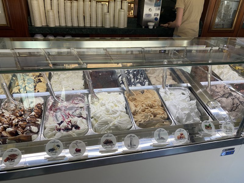 Various gelato flavors behind shop glass counter