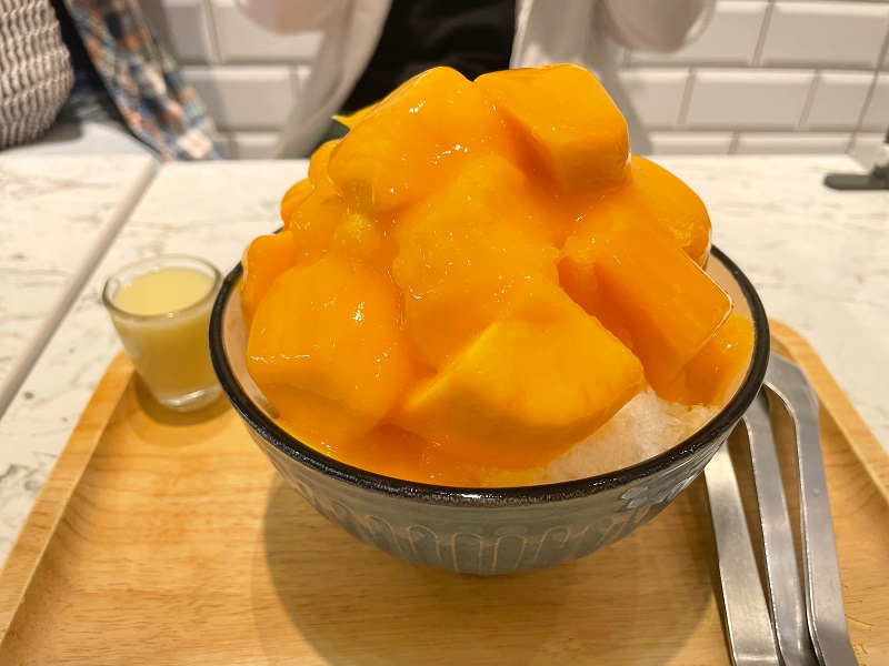 shaved ice with mango and condensed milk on top