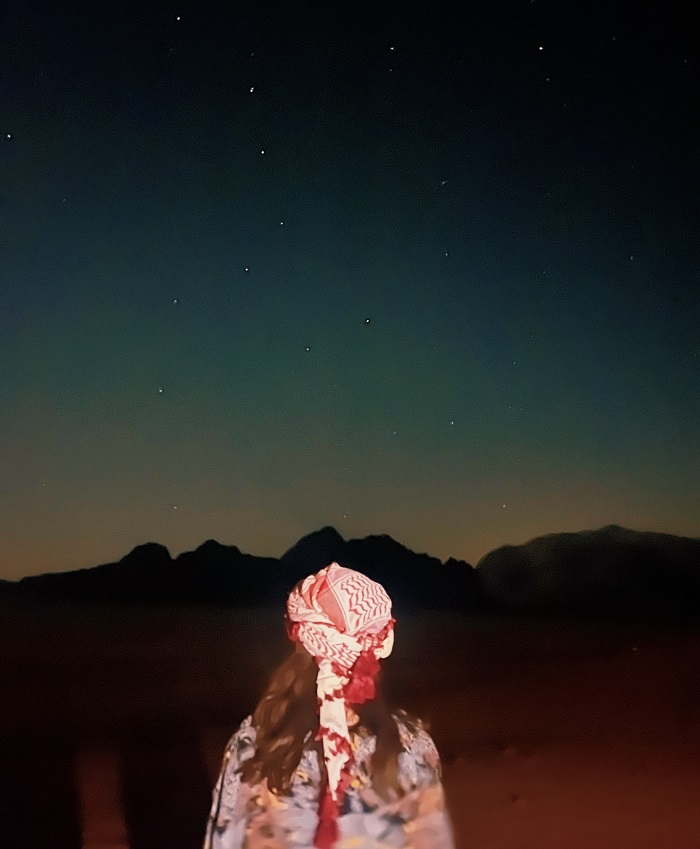 Grace wearing a headscarf staring at the night sky