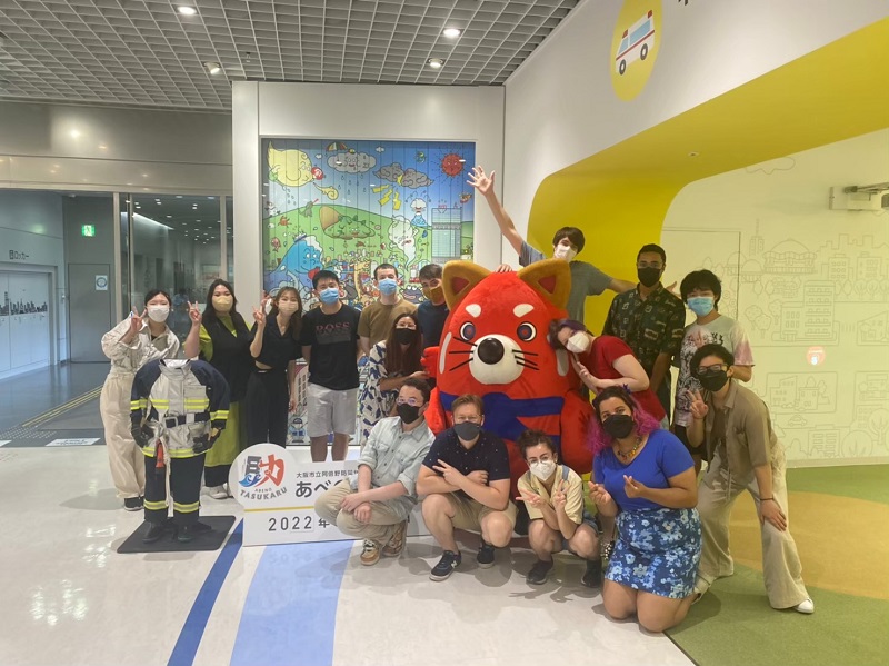 group of CET students posing with the disaster center mascot 