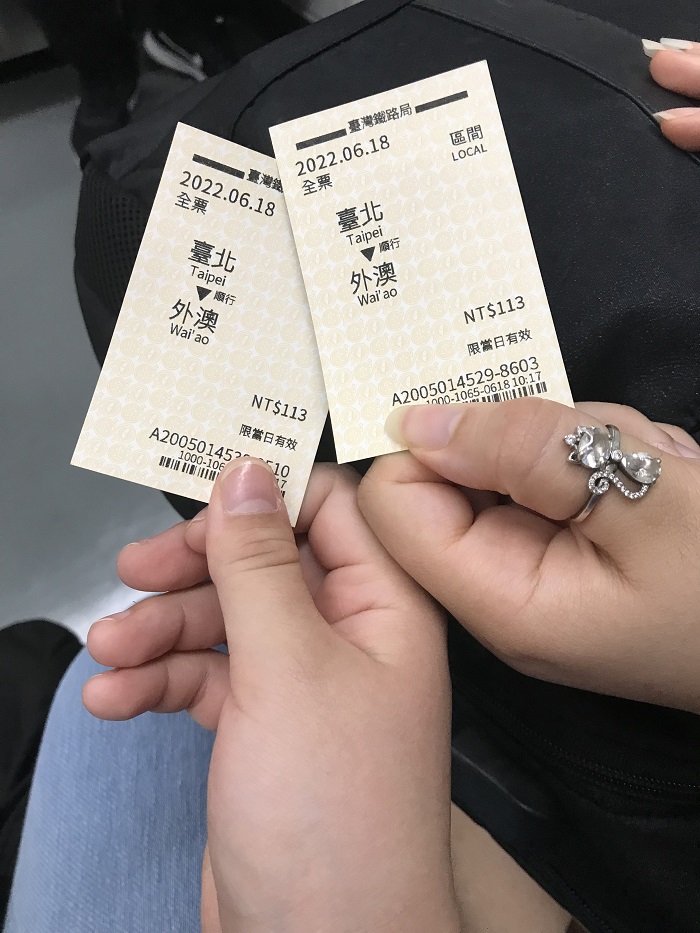 two hands holding train tickets 