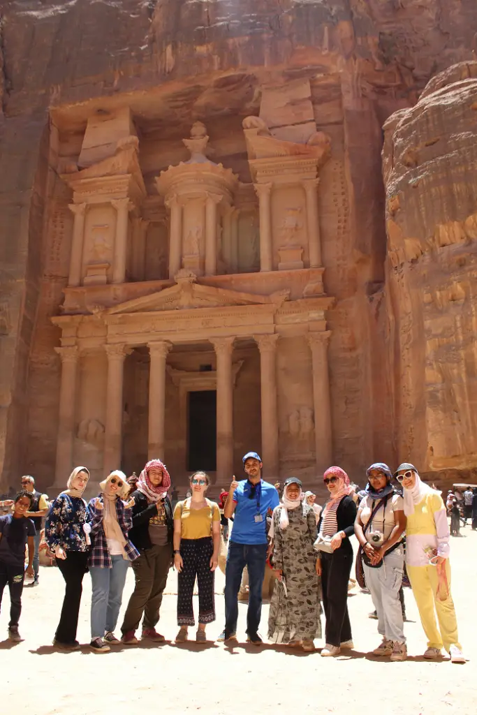 students posing in front of very large rock treasury