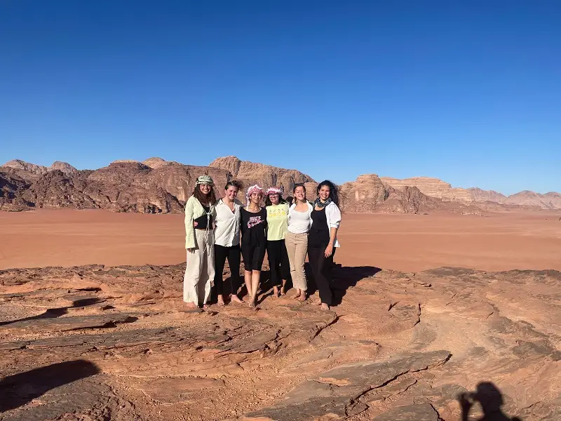 Group of CET Students standing on sand dune in the desert