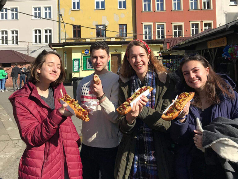 Students eat from a food stand on the streets of Prague