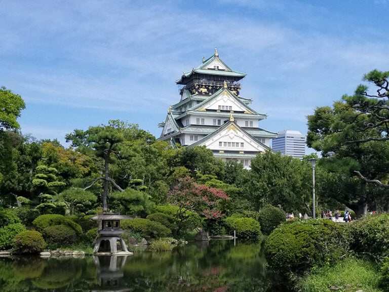 View of Osaka Castle with a pond in the foreground