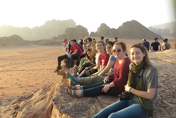 CET Jordan students sit on a rock in Wadi Rum