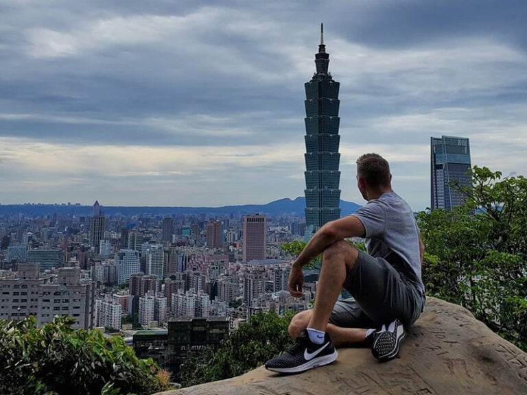 CET Taiwan student sits on top of a mountain overlooking Taipei