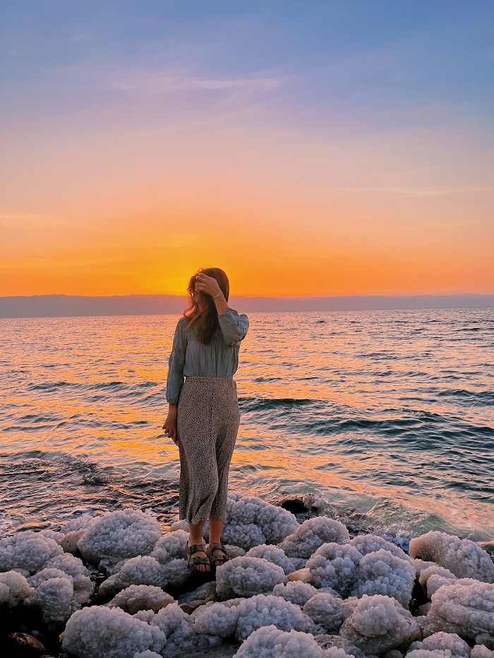 Grace standing on salt formations in the dead sea during sunset 