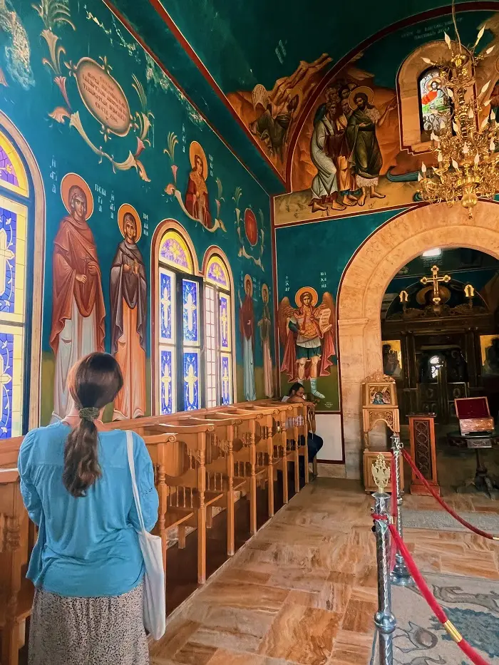 Grace standing in church with art on the walls