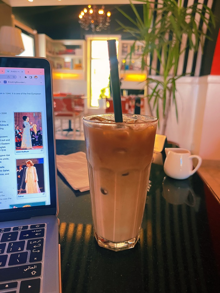 Ice coffee next to a laptop in a café 