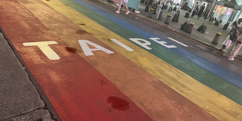 A paved street painted with a rainbow and the word "Taipei" written across it