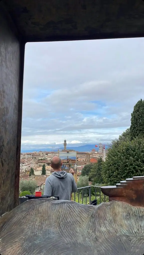 A man painting the view on an easel. 