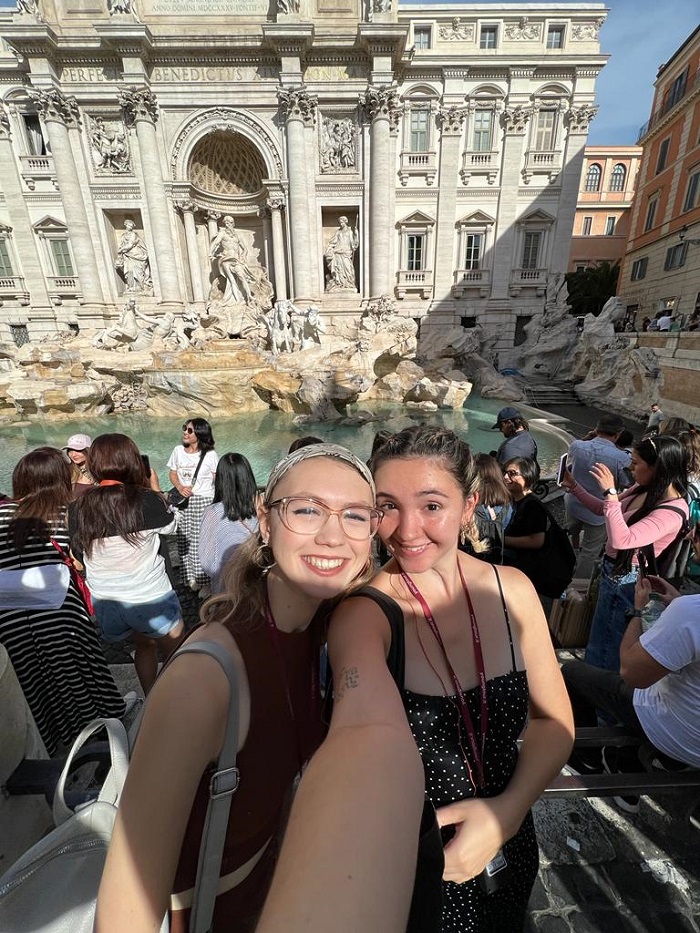 Students taking a selfie in front of the Trevi Fountain in Rome, Italy