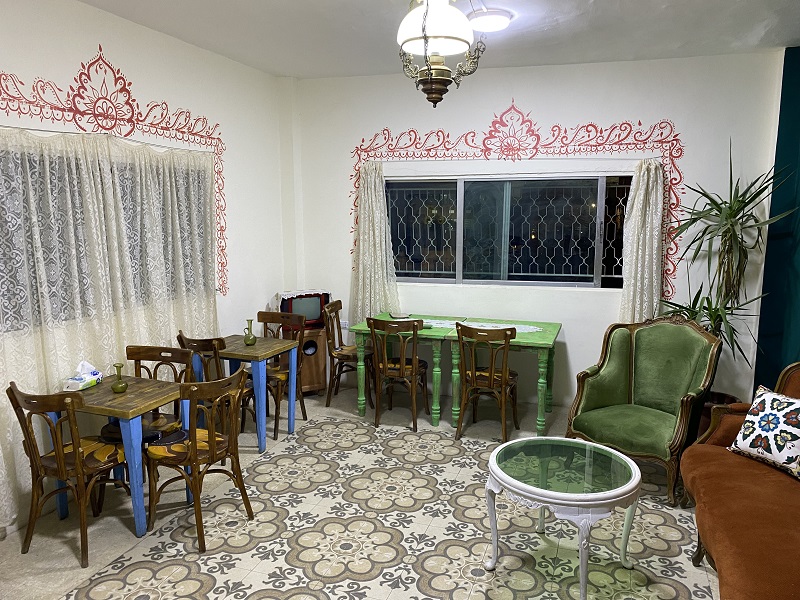 The top floor of a café in West Al-Balad with chairs, sofas, and tables