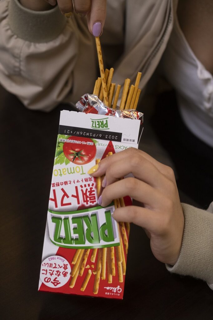 A close up shot of a student eating Tomato flavored Pretz.