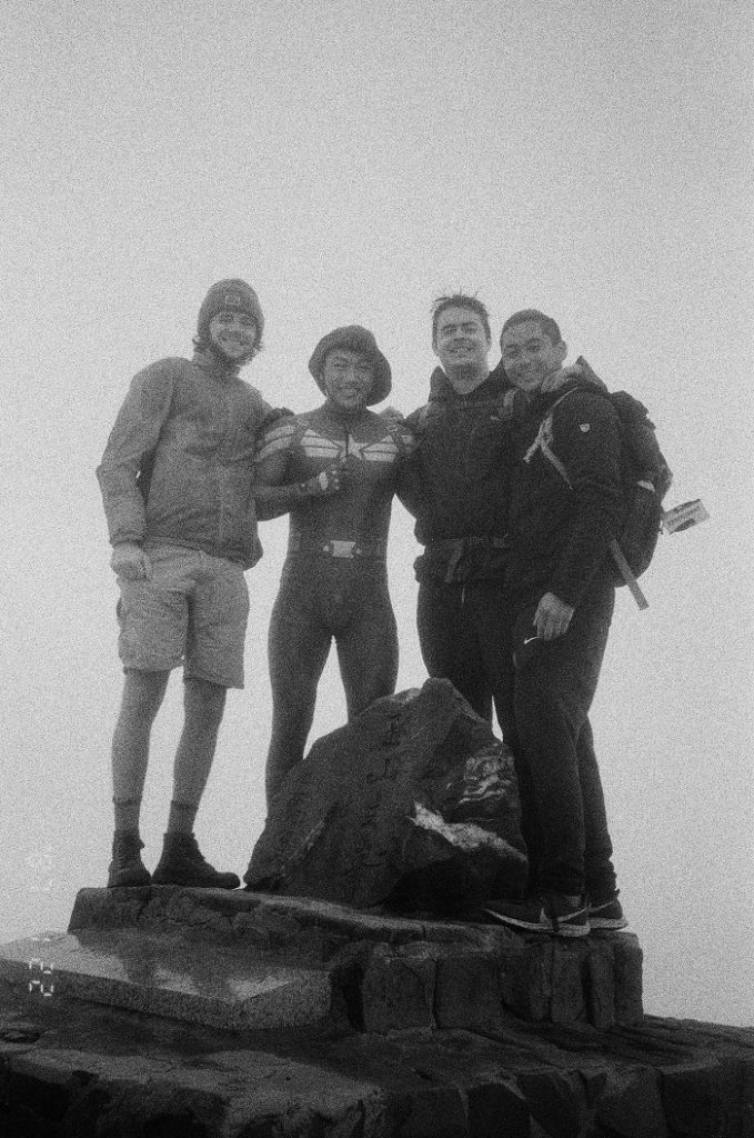Students and another hiker posing on top of a mountain in Taiwan