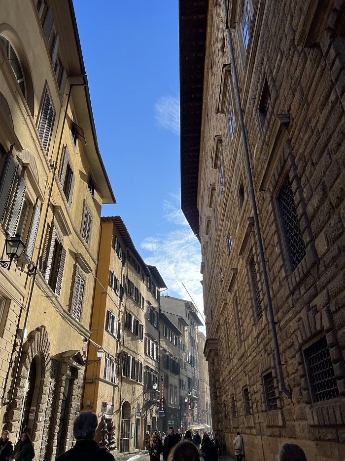 A narrow street in Florence lined with shops and apartments on both sides