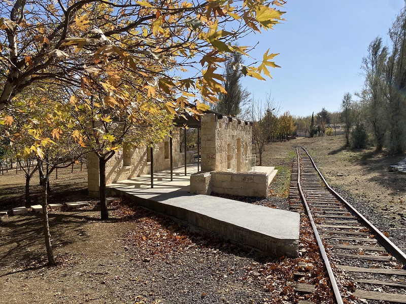 An old train station at Al-Hussein Park with yellow leaved trees on the left