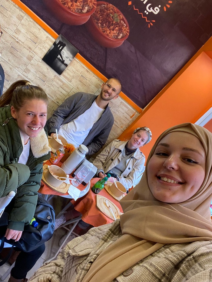 Students smiling in a selfie after eating lunch at a restaurant in Amman.