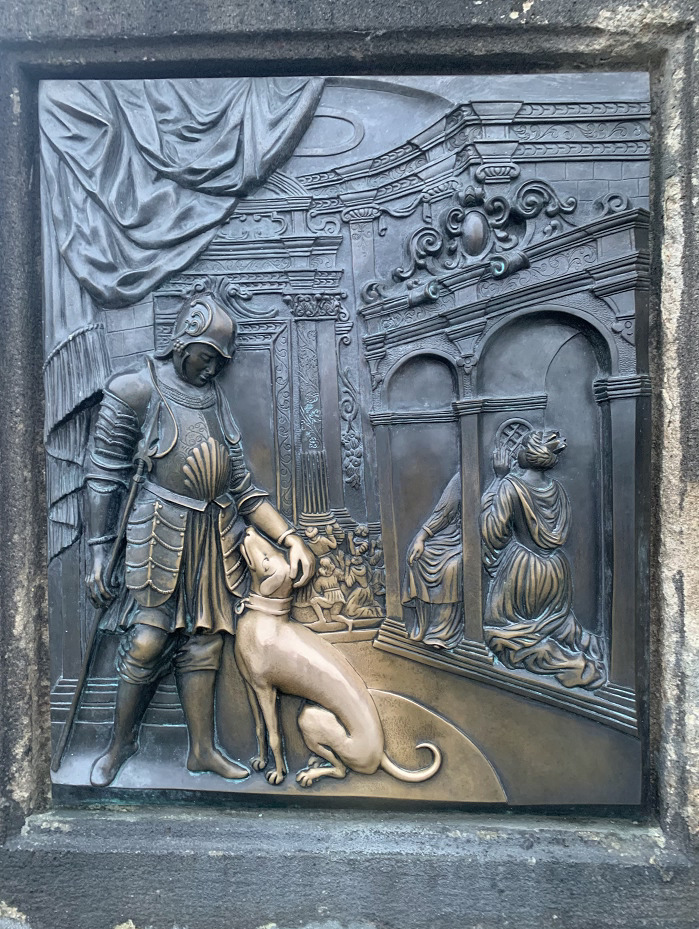The story of Saint John of Nepomuk memorialized on the Charles bridge where a solider is petting a dog