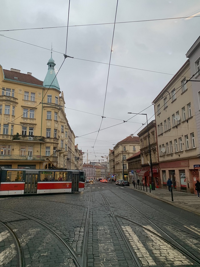 Street of Prague with a tram, cars, and people