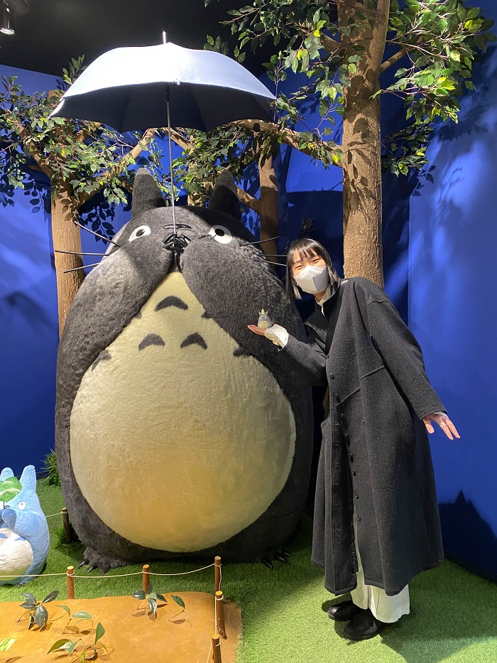 A CET student posing next to Totoro in front of a store in Japan