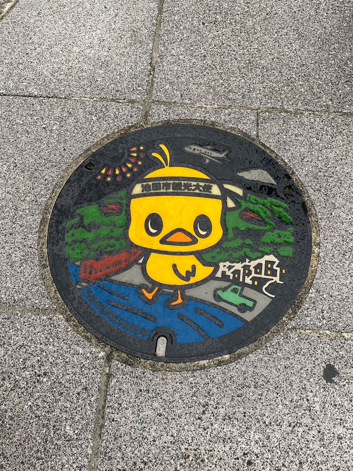 A large duck mascot on a manhole cover in Japan