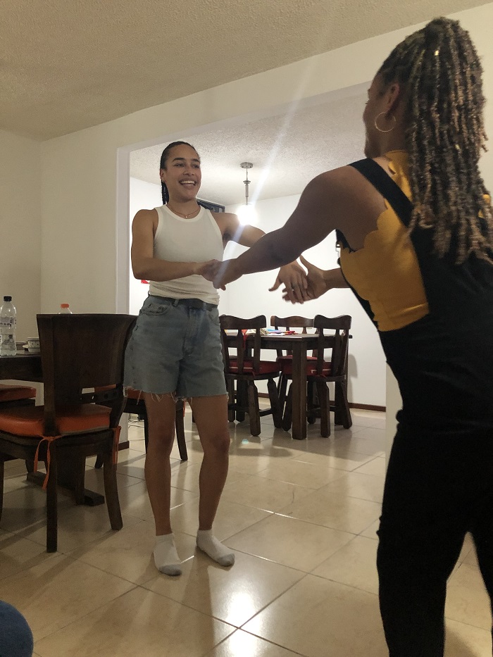Two CET students dancing in the living room space