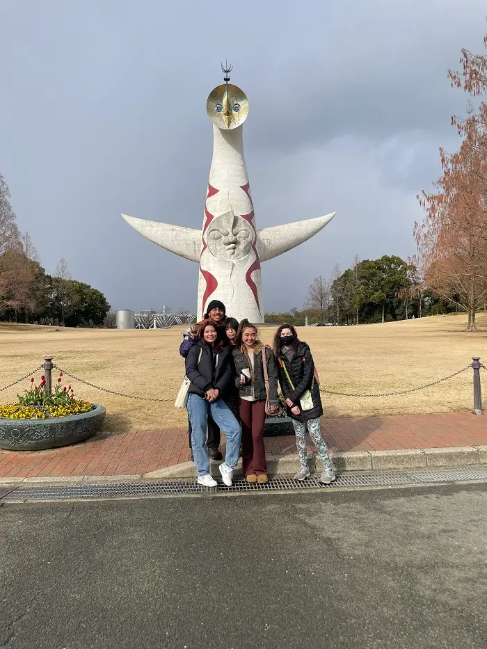 CET and Osaka Gakuin students in front of a giant white Tower of the Sun