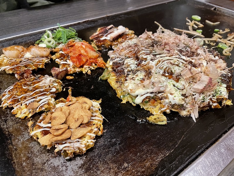 Multiple okonomiyakis cooking on a skillet 