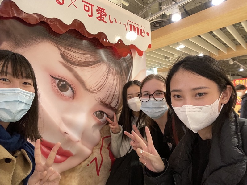 CET students and her roommates posing in front of a Japanese purikura  photobooth