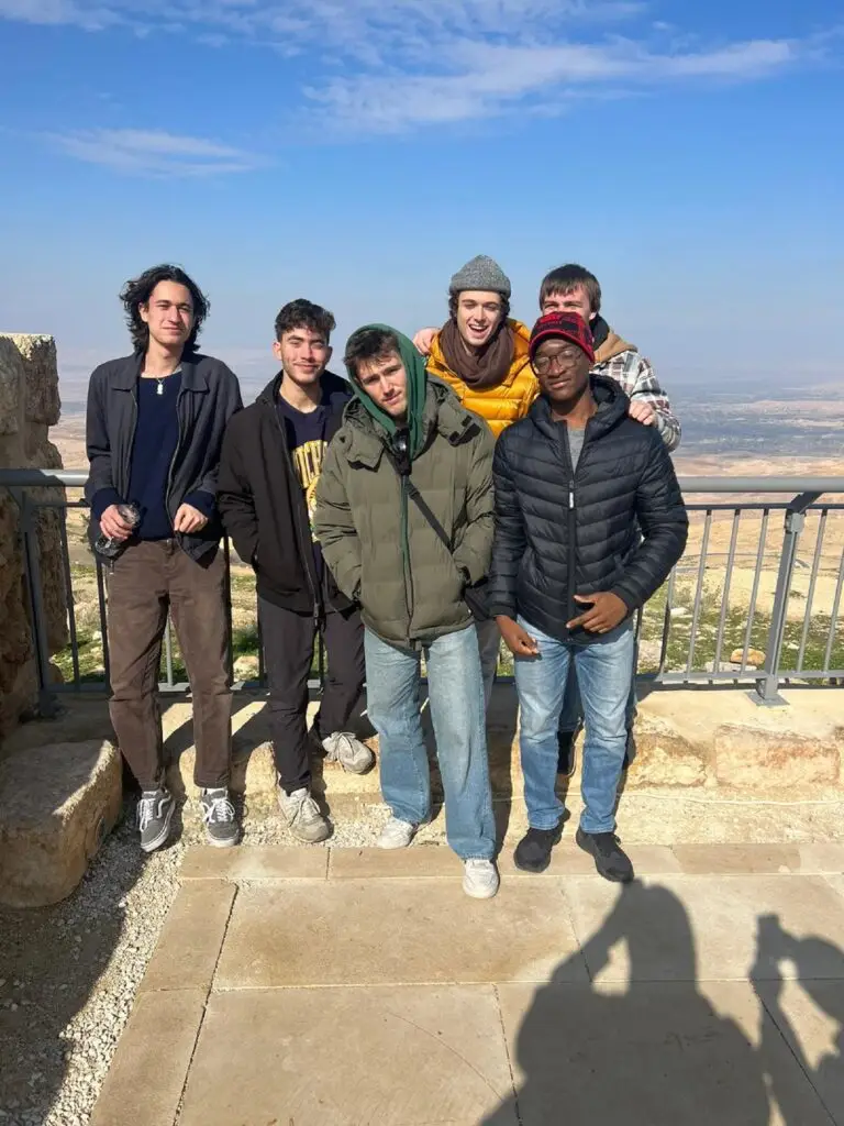 A group of male CET Jordan students in front of a scenic view in Amman, Jordan