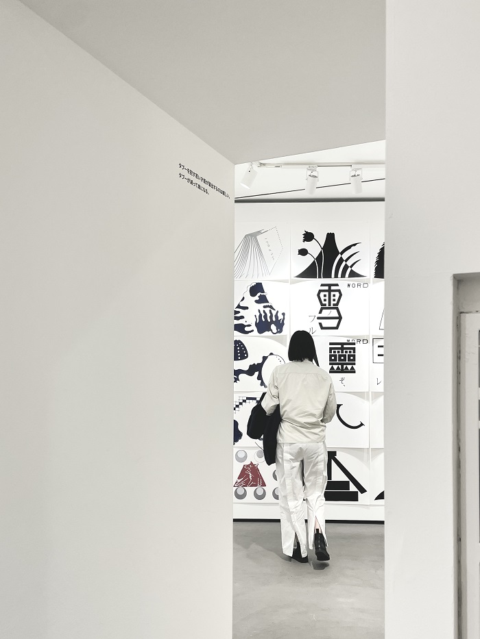 A CET student looking at a wall of white and black art pieces in a design gallery in Osaka, Japan