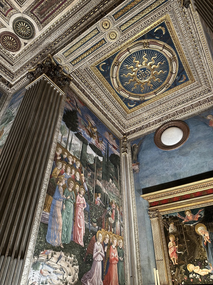 The inside of Palazzo Medici Riccardi with frescos and intricate designs on the walls with accents of gold, red, blue, green art 