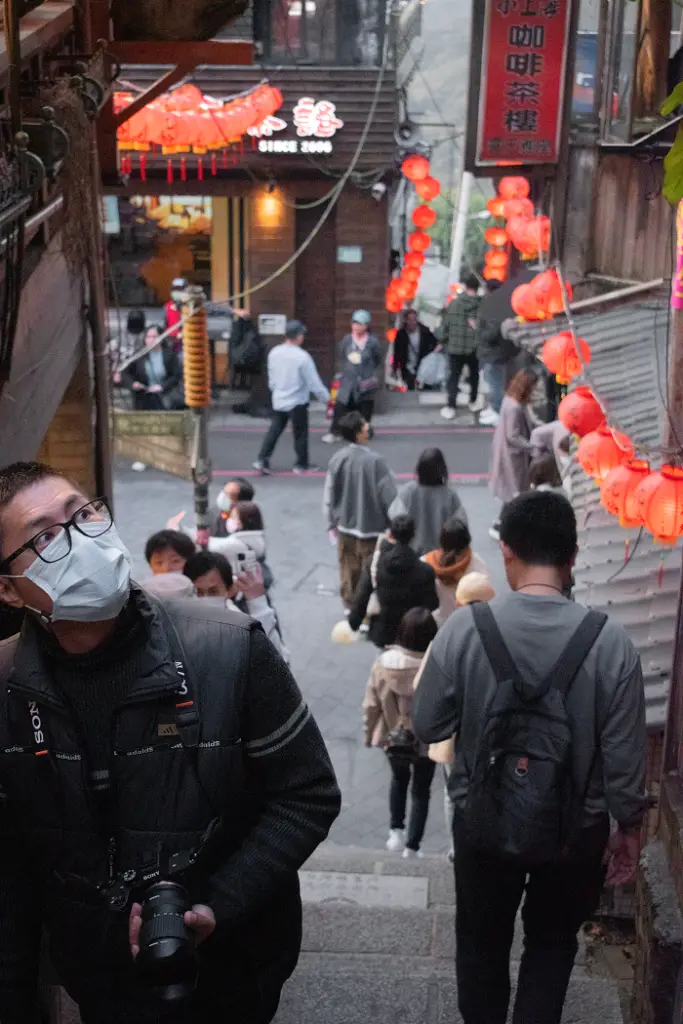A staircase and street further into Jiufen with people walking up and down on both sides.