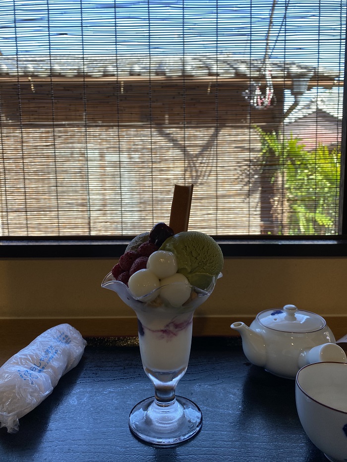 Parfait ice cream in a glass cup set on a table by a window in a parfait shop