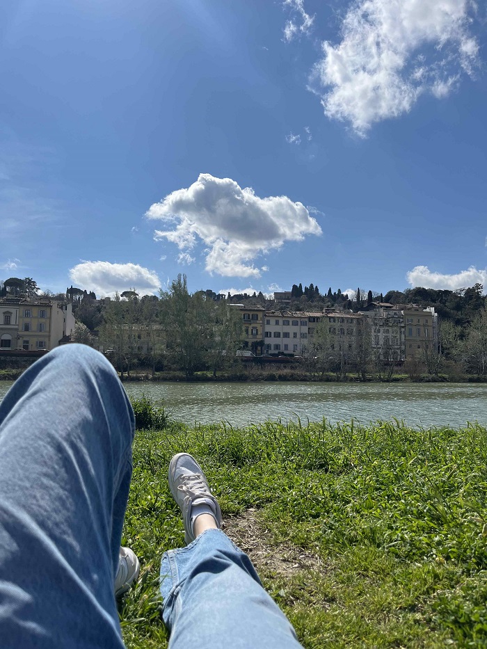 Legs of a CET Florence student while lying on the grass by the Arno River in Florence, Italy