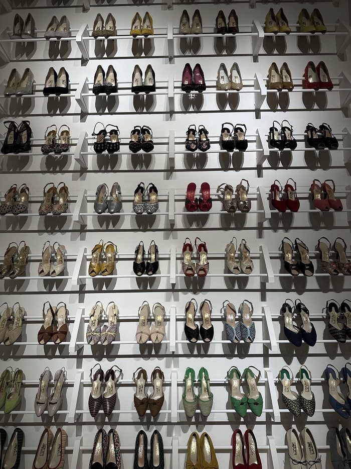 An array of shoes lined up together against a wall in the Ferragamo Museum