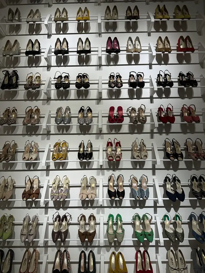 An array of shoes lined up together against a wall in the Ferragamo Museum