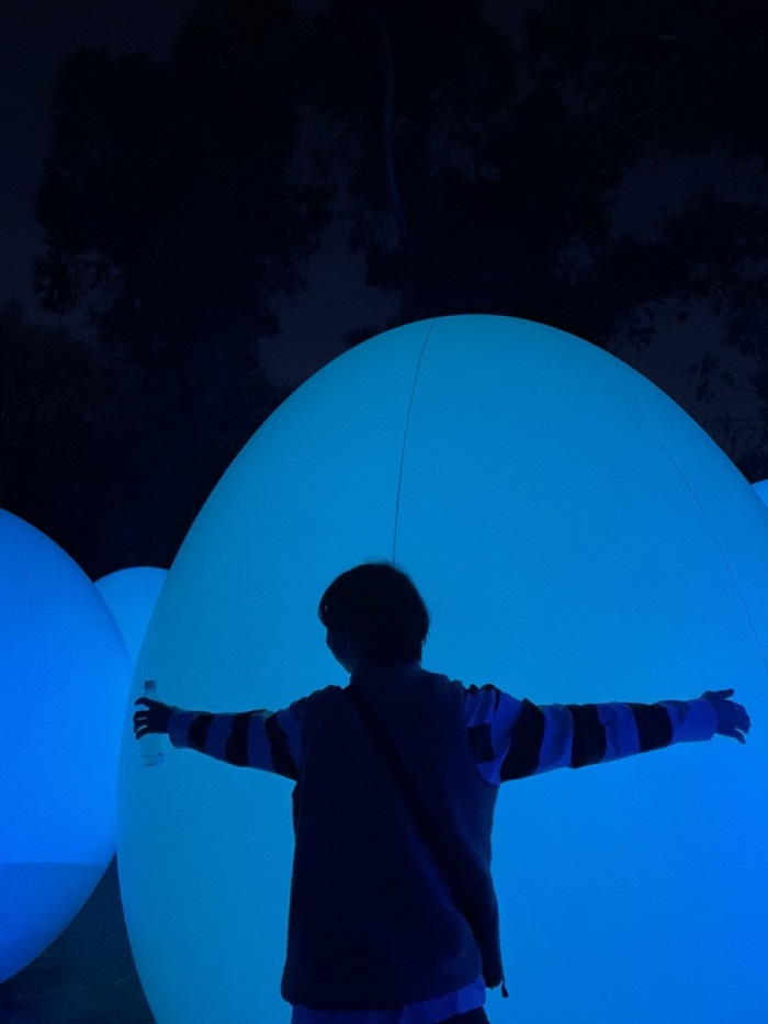 Somebody hugging a giant egg-shaped inflatable in teamLab Botanical Garden in Osaka, Japan