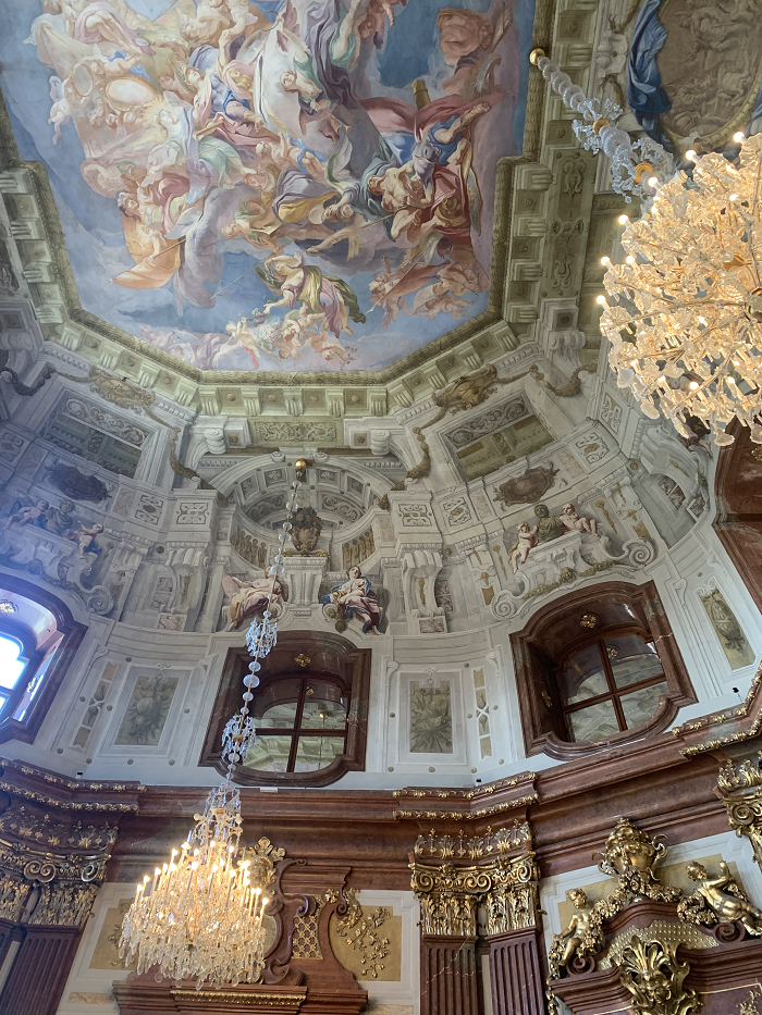 The ceilings at the Belvedere Museum in Vienna painted with pastel colors with two chandelier hanging in the room