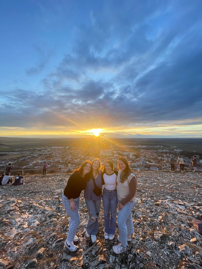 Four CET Prague female students smiling on top of a hill in Mikulov with at sunset