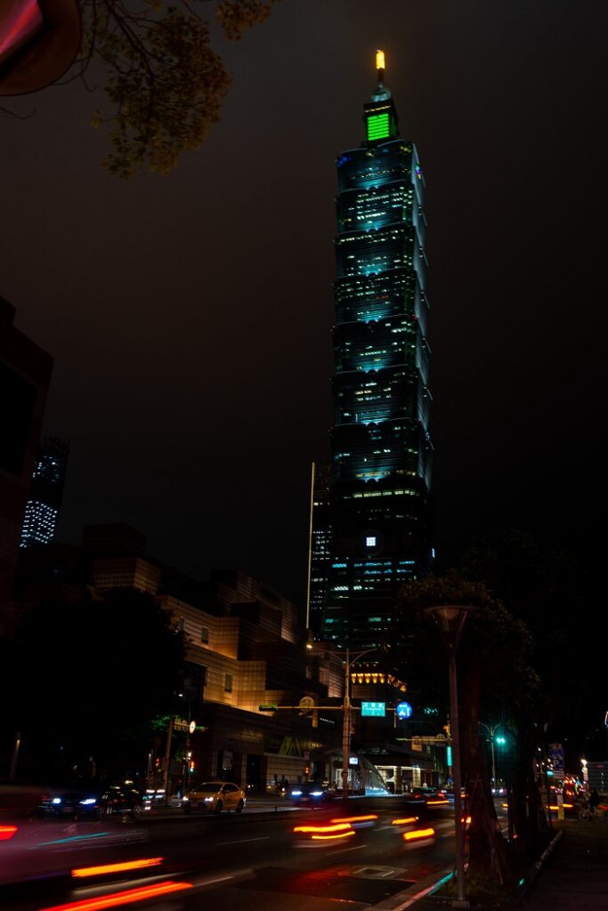 Taipei 101 lit up at night with car lights streaking 
