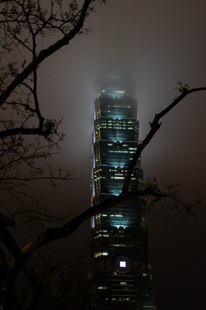 Close-up of Taipei 101 lit up on a foggy night
